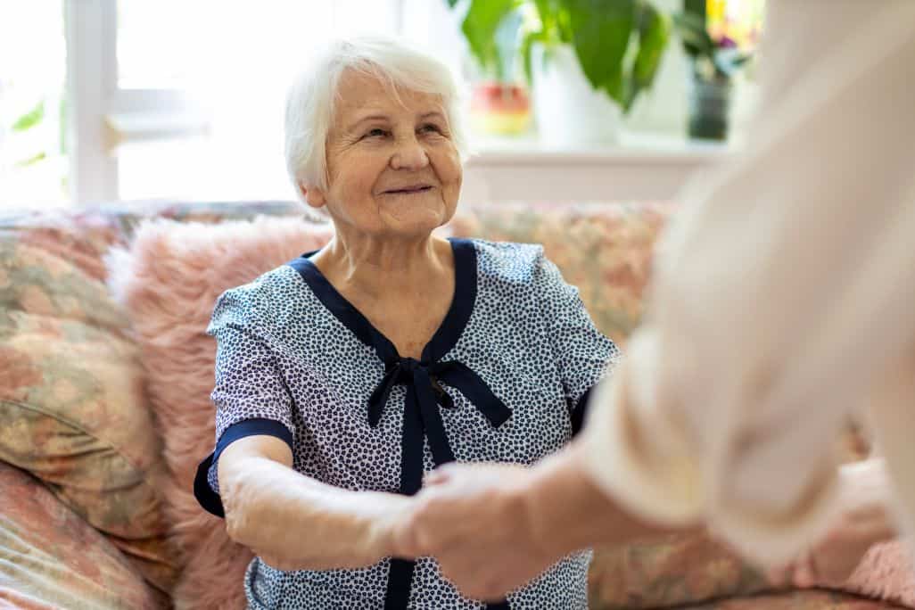Adult caregiver helping a loved one transition to memory care.