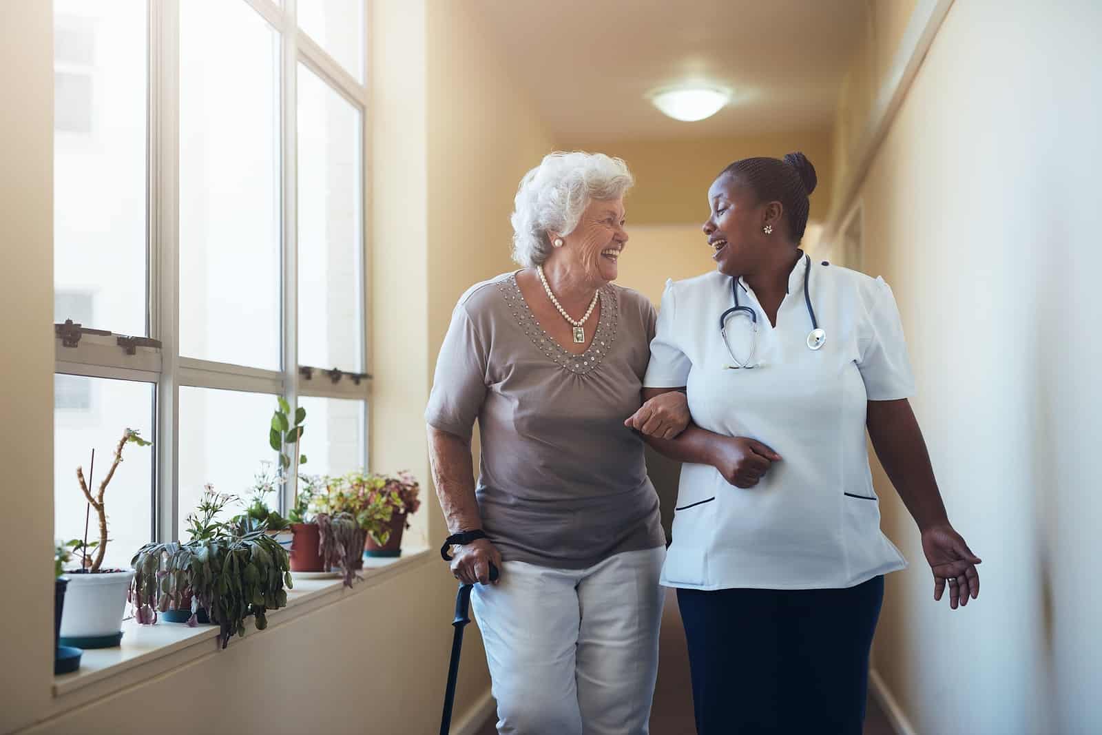 A happy staff member telling a resident about the benefits of assisted living.